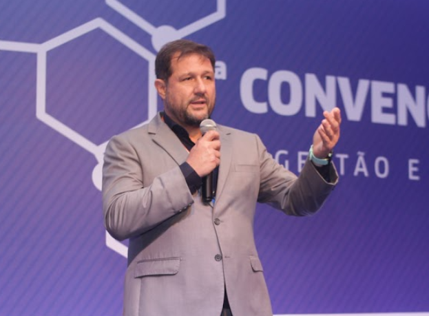Dr. João Buck falando ao microfone durante uma convenção.